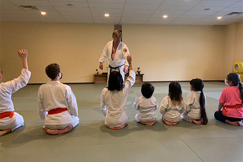 Sensei instructing a line of children sitting at attention